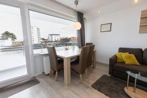 a dining room with a table and chairs and a couch at Hanseatic 208 in Duhnen