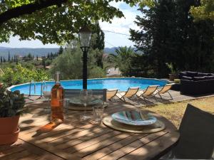 - une table avec une bouteille de vin à côté de la piscine dans l'établissement Villa Mas de la Roche, à Fayence