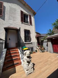 a house with a stone lion on a wooden deck at Soleil in Villejuif