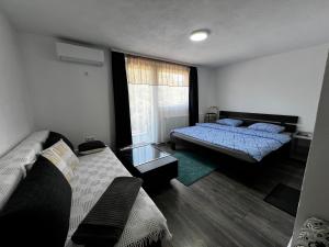 a bedroom with two beds and a window at Apartman UnaTesnim in Bihać