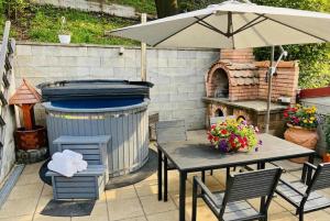 a patio with a table and an umbrella and a grill at Kral Villa in Sovata