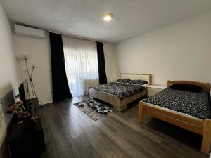 a bedroom with two beds and a window at Apartman UnaTesnim in Ripač