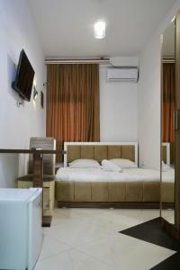 a bedroom with a bed and a television in it at Hotel Heimli in Prishtinë