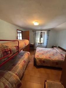 a hotel room with two beds and a window at LOCANDA Alla Paia in Pracul