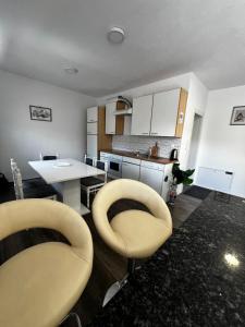 a kitchen with two chairs and a table in it at Apartman UnaTesnim in Ripač