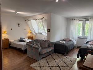 a bedroom with a bed and a couch and a chair at Gosciniec Pod Brzozami in Poznań