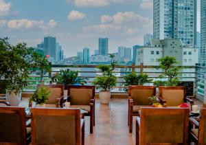 a balcony with tables and chairs and a city skyline at 그레이스 호텔 Grace Hotel & Residence in Hanoi