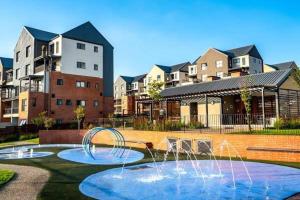 a fountain in a yard in front of some buildings at Luxury Apartment - Breathtaking River Views in Kyalami