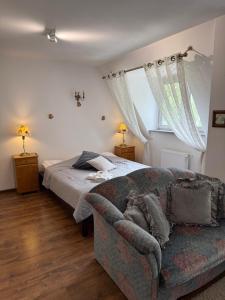 a bedroom with a bed and a couch at Gosciniec Pod Brzozami in Poznań