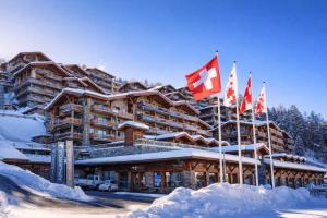 a large building with flags in front of it at Vue Alpes imprenable - Centre - 4 Vallées in Nendaz