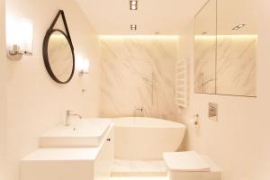 a white bathroom with a sink and a mirror at Mint Luxury Apartments at the Main Square in Krakow