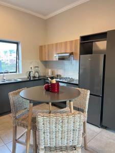 a kitchen with a table with chairs and a refrigerator at Luxury Apartment - Breathtaking River Views in Kyalami