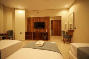 a hotel room with two beds and a flat screen tv at Sama Hotel Sherif Basha in Cairo
