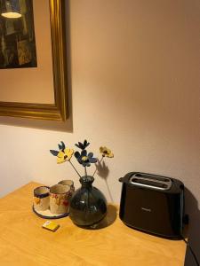 a table with a toaster and a vase with flowers at Ferienwohnung Zum Bachsee in Chorin