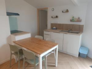 a kitchen with a wooden table and chairs at La parenthèse Audomaroise in Heuringhem