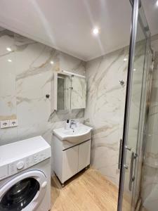 a bathroom with a sink and a washing machine at evelinas view 3 in Mytilene +22 photos