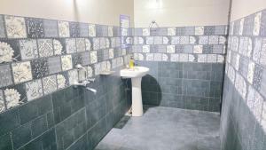 a bathroom with a sink and a green tiled wall at Avante Palace in Rānchī +33 photos