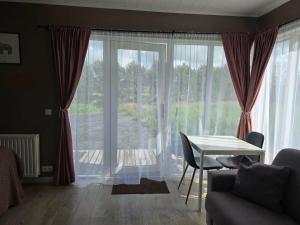 a living room with a table and a large window at Romantic Getaway in Fludir