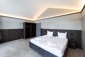 a bedroom with a large bed with white sheets at Chalet Rila in Govedartsi