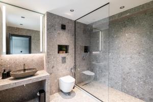 a bathroom with a glass shower with a sink and a toilet at Chalet Rila in Govedartsi +27 photos