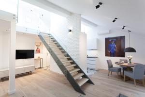 a staircase in a living room next to a dining room at MINT Luxury Apartments at the Main Square in Krakow