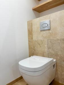 a white toilet in a bathroom with a sign on the wall at Hébergement standing au calme in Saint-Maximin-la-Sainte-Baume