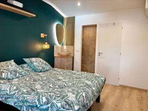 a bedroom with a bed and a green wall at Hébergement standing au calme in Saint-Maximin-la-Sainte-Baume