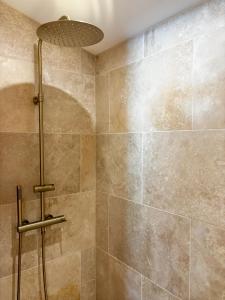 a bathroom with a shower with a tile wall at Hébergement standing au calme in Saint-Maximin-la-Sainte-Baume