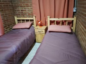 two beds sitting next to each other in a room at Cabaña María Lourdes in Maipú