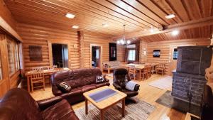 a living room with leather furniture in a log cabin at Loma-Pälsilä lakeside villa in Kuhmoinen