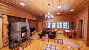 a living room with a fireplace and a dining room at Loma-Pälsilä lakeside villa in Kuhmoinen