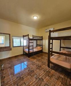 a room with three bunk beds and a wooden floor at Shamsa Chalet in Al Mazār