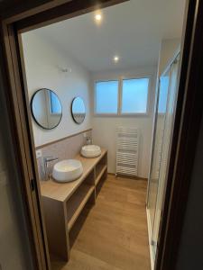 a bathroom with two sinks and two mirrors at Maison proche grande plage in Quiberon