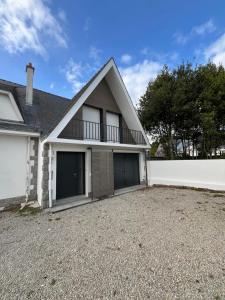 a house with two garage doors and a white fence at Maison proche grande plage in Quiberon