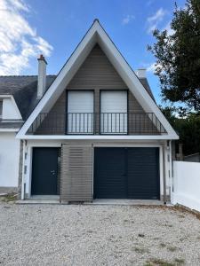 a house with two garage doors and a balcony at Maison proche grande plage in Quiberon +20 photos