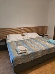 a bed with two towels sitting on top of it at Porta Del Ricetto in Candelo