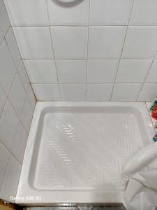 a white bath tub in a white tiled bathroom at Siciliana in Caronia