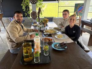a group of people sitting at a table with food at Misty mountains residents in Huluganga