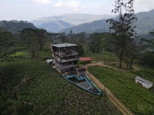 an aerial view of a house in a field at Misty mountains residents in Huluganga +3 photos
