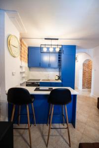 a kitchen with blue cabinets and two bar stools at Serenity Sea in Perast