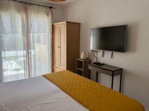 a bedroom with a bed and a flat screen tv at Chambre Villa piscine in Saint-Tropez