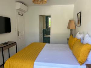 a bedroom with a large bed with yellow pillows at Chambre Villa piscine in Saint-Tropez