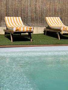 two beach chairs sitting next to a swimming pool at Chambre Villa piscine in Saint-Tropez