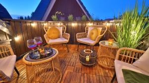 a patio with wicker chairs and tables and lights at Green Loft Schwarzwald - Dach-Balkon--Musik-Ecke in Winzeln