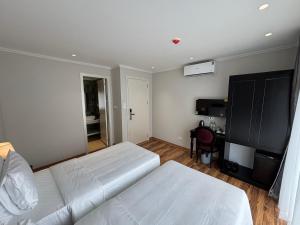 a bedroom with two white beds and a desk at Classy Central Hotel in Hanoi