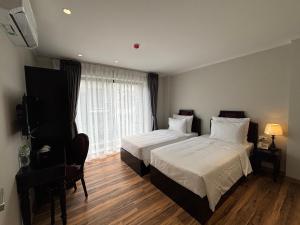 a hotel room with two beds and a television at Classy Central Hotel in Hanoi +32 photos