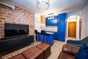 a living room with blue cabinets and a flat screen tv at Serenity Sea in Perast