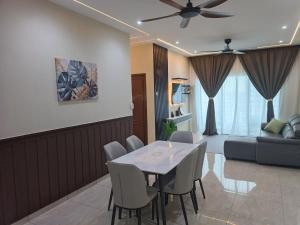 a living room with a table and chairs and a couch at JayR Homestay Ambience Residence in Malacca