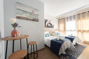 a bedroom with two beds and a table in it at Emarooms Boutique Laredo in Laredo