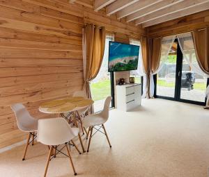 ein Esszimmer mit Tisch, Stühlen und Flachbildfernseher in der Unterkunft Venice barn Przełazy in Przełazy